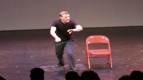 David Harris standing next to a red chair